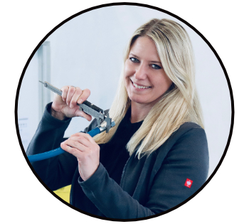 Technikerin misst mit einer Schiebelehre die Verpressung einer Hydraulikarmatur an einem Hydraulikschlauch