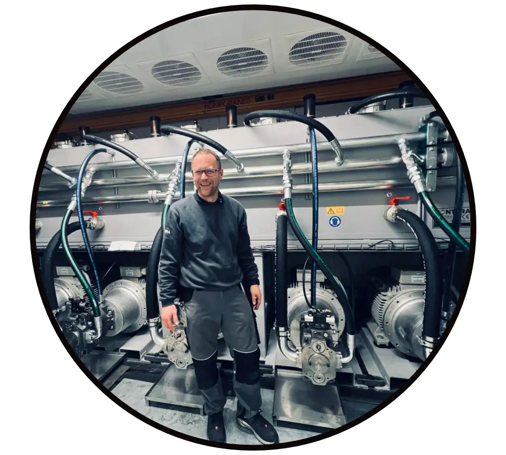 Hydraulikaggregat Inbetriebenahme mit Hydraulik Wartung und Instandhaltung Das Bild zeigt Michael Güttersberger bei Inbetriebnahme eines kompletten Hydraulikaggregats mit Pumpen unter dem Tank, Hydraulikmotore und angeschlossenen Druck- und Saug Schläuchen und Hydraulikrohren