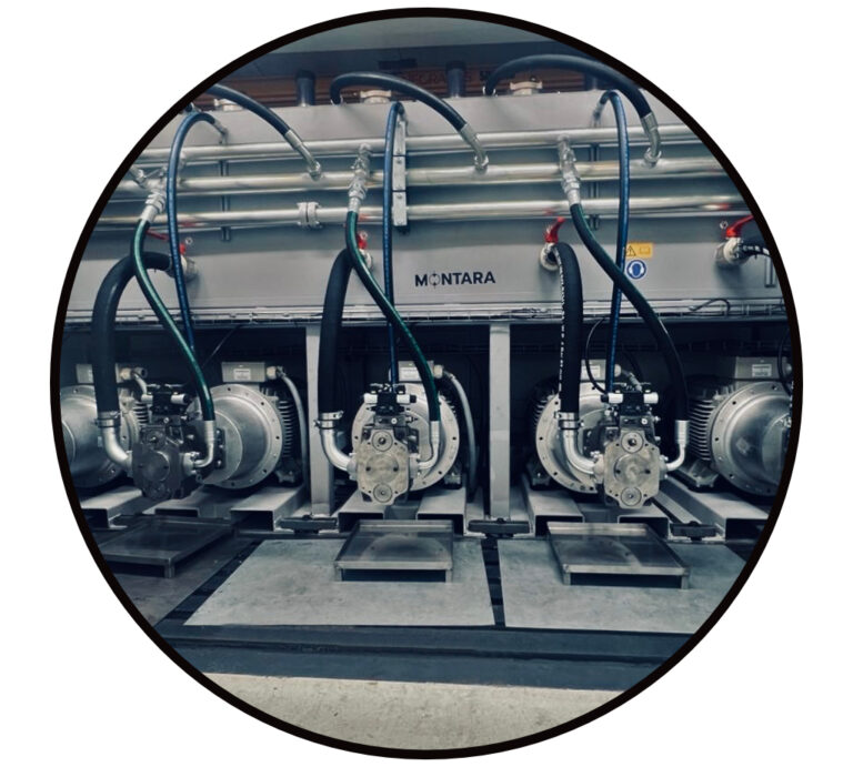Komplettes Hydraulikaggregat: Pumpen unter dem Tank, mit Hydraulikmotore und angeschlossenen Druck- und Saug Schläuchen und Hydraulikrohren