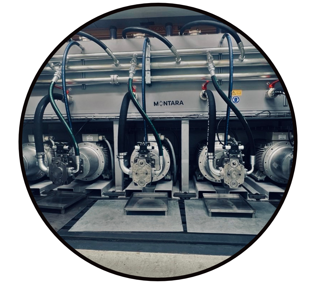 Komplettes Hydraulikaggregat: Pumpen unter dem Tank, mit Hydraulik Motor und angeschlossenen Druck- und Saug Schläuchen und Hydraulikrohren