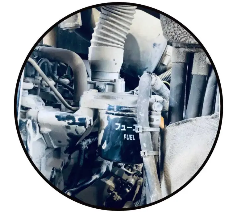 Hydraulik Fehlersuche im inneren einer Baumaschine. Das Bild zeigt Hydraulikschläuche und einen Kraftstofffilter