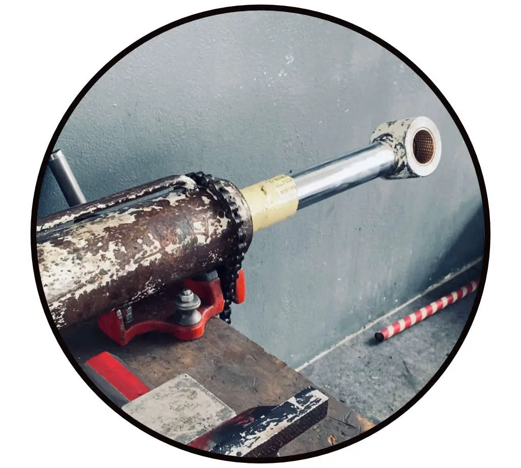 Hydraulikzylinder in einem Kettenschraubstock eingespannt für die Reparatur - sicheres Fixieren für die Instandsetzung