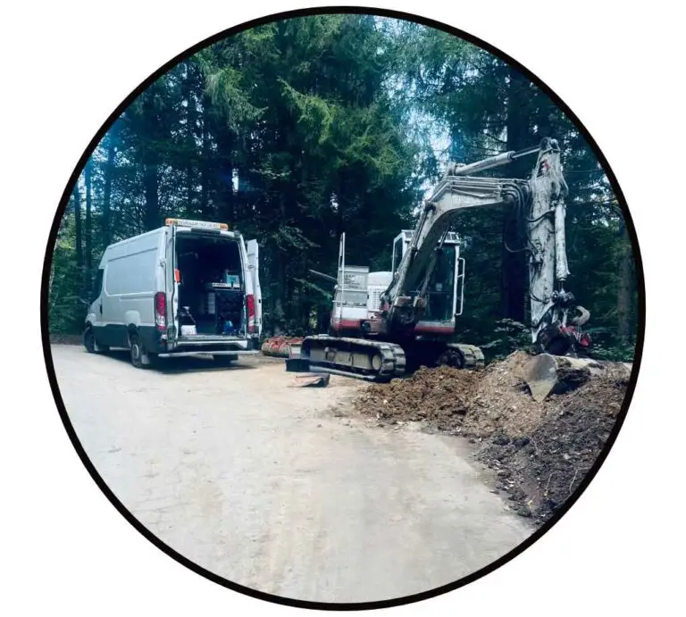 Hydraulik Notdienst Montagebus im Wald neben einem Bagger der an der Hydraulik repariert wird