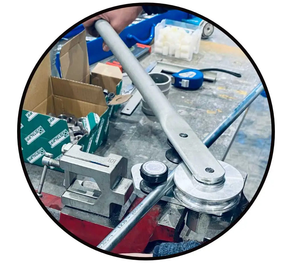 Hydraulikrohre biegen mit manuellem Rohrbiegegerät eingespannt in einem Schraubstock mit Hebelmechanik.